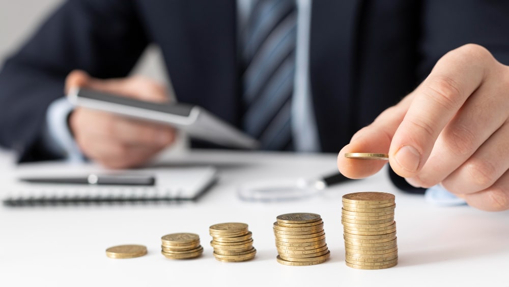 man calculating Bulgaria dividend tax splitting coins in piles